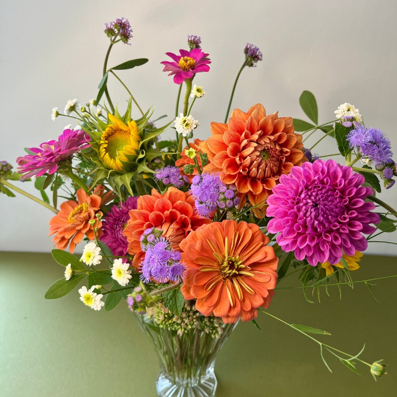 Pink and orange flowers with a sunflower in a decorative vase, delivered in Jackson, Wisconsin